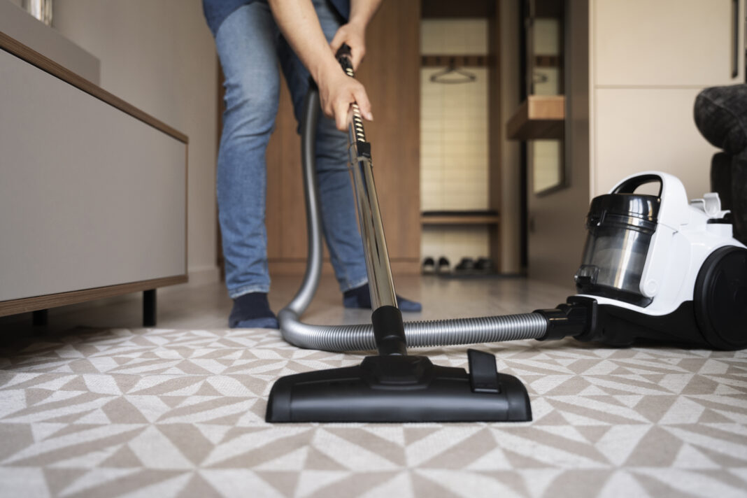 Man vacuuming his house late at night in the Netherlands.