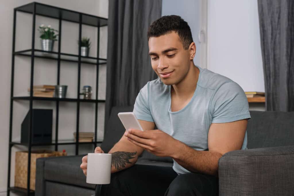 man-sitting-on-couch-investing-money-from-his-phone-in-the-netherlands
