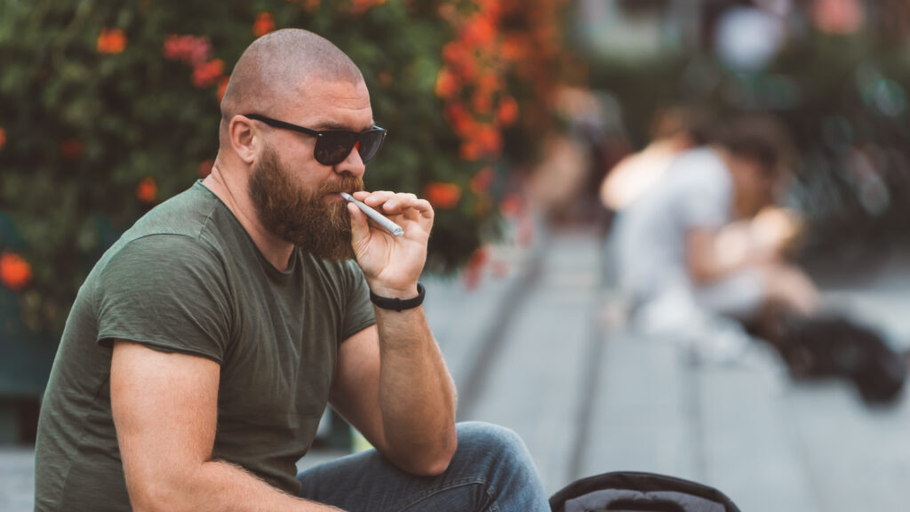 photo-of-man-sitting-in-park-in-amsterdam-smoking-joint