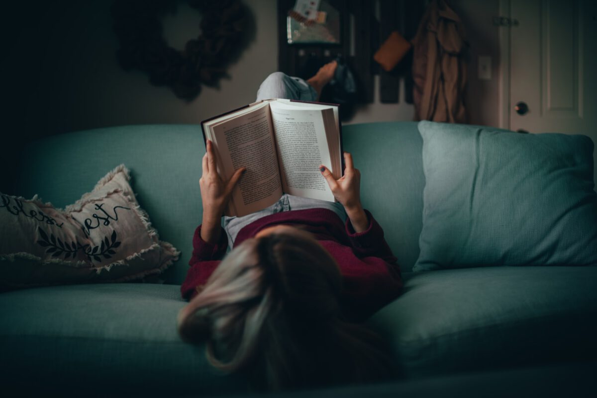 Photo-of-woman-reading-book-on-couch