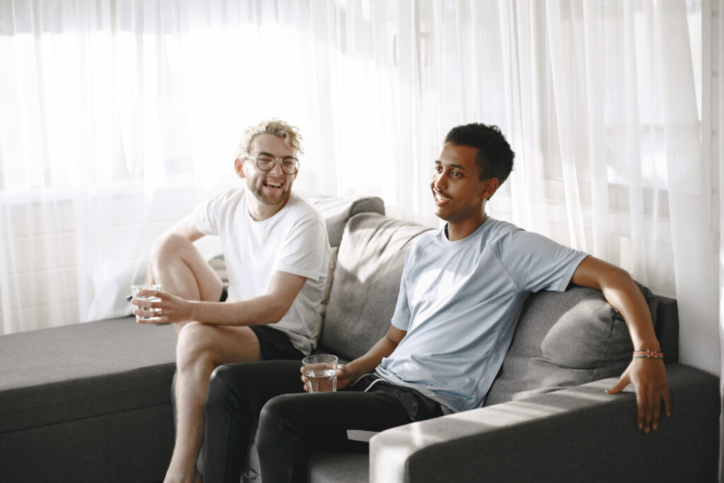 Male friends watching tv-channels-in-the-netherlands together in a bright room
