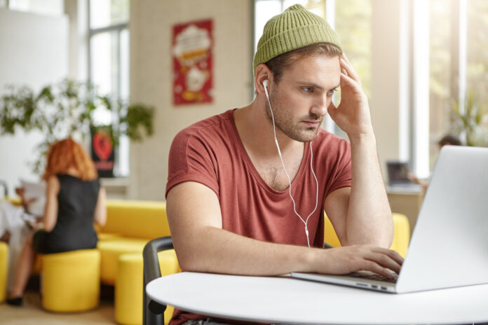 photo-of-man-looking-at-computer-checking-monthly-wage-2025