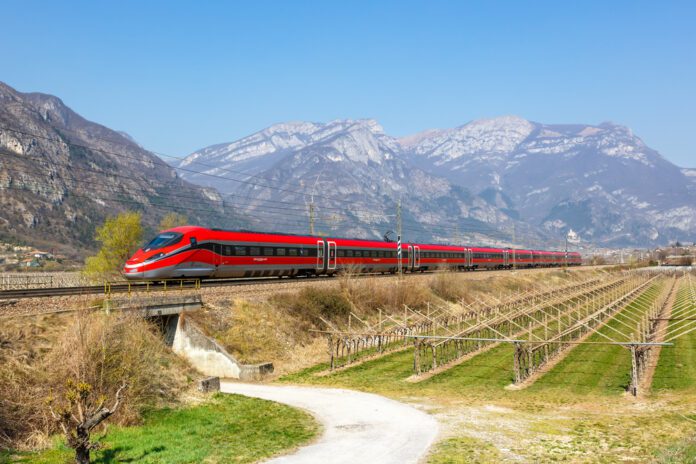 photo-of-italian-company-train-fs-in-big-field-with-mountains-in-the-background-for-more-international-european-train-travel
