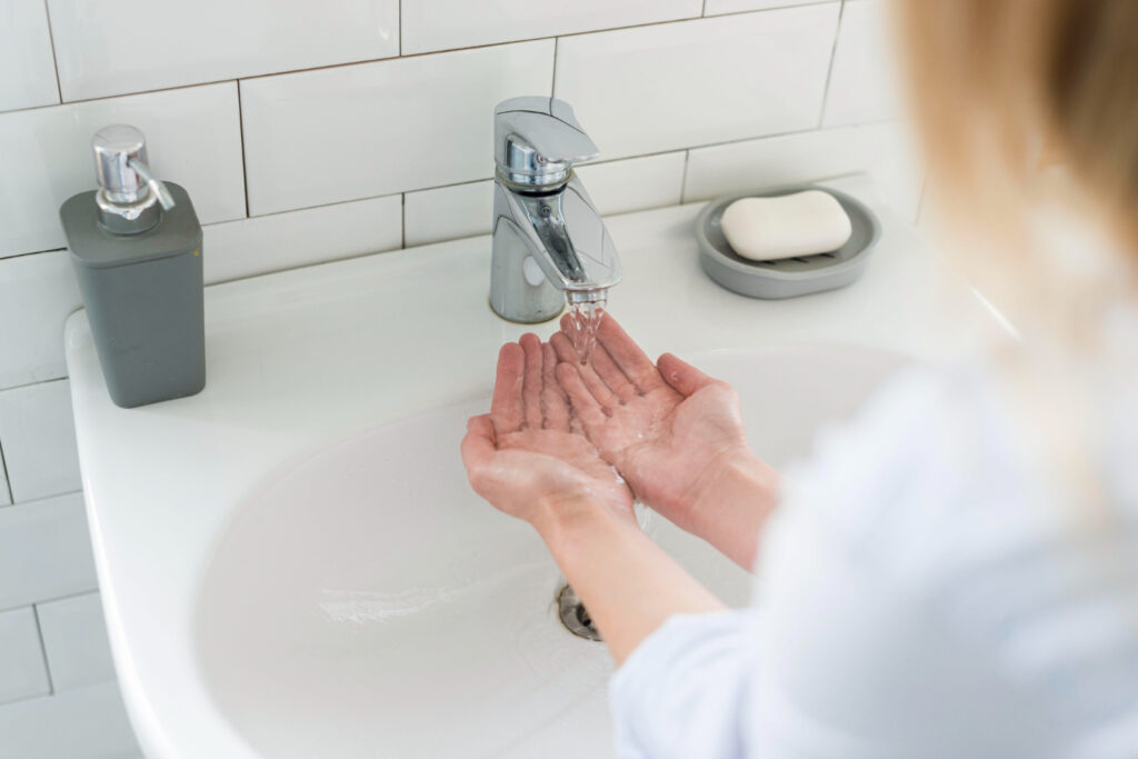 photo-of-woman-washing-hands-in-sink-after-moving-house-netherlands-and-setting-up-utilities