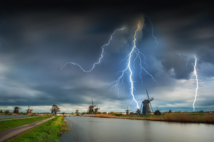 photo-of-windmills-under-dark-stormy-sky-with-lightning-strikes