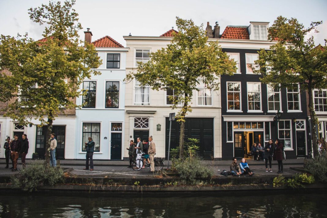 photo-of-a-group-of-people-standing-in-front-of-dutch-houses