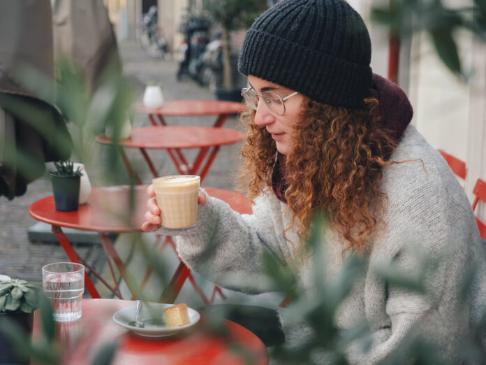 photo-of-woman-with-oat-milk-cappucino-sitting-outside-cafe-in-Amsterdam