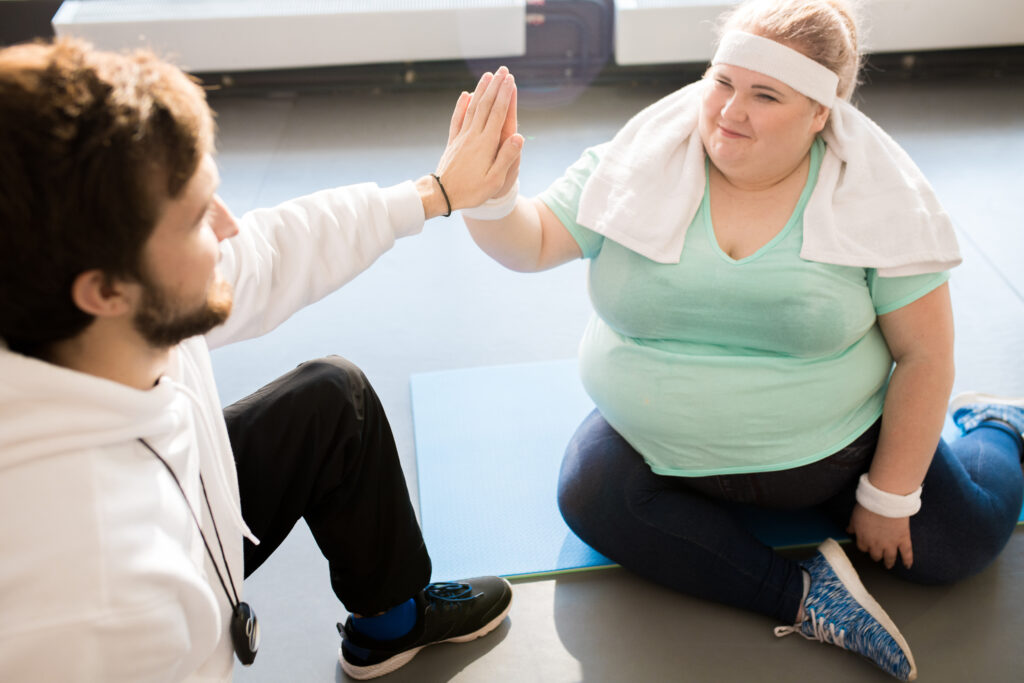 obese-woman-at-dutch-gym-high-fiving-her-personal-trainer-helping-with-weight-loss