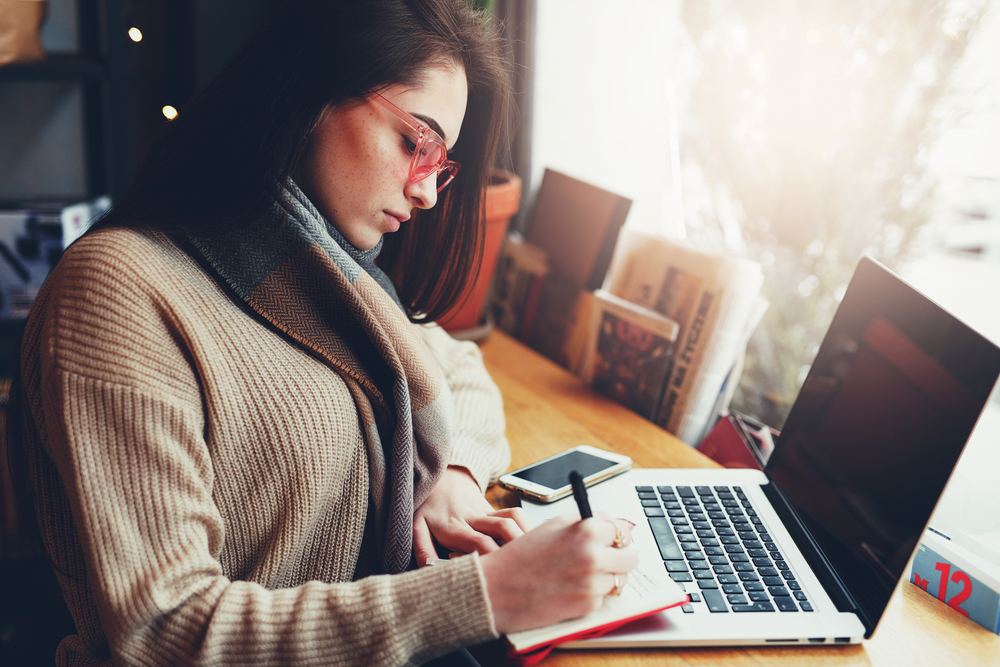 photo-young-woman-sits-in-a-cafe-practicing-dutch-grammar-online-free