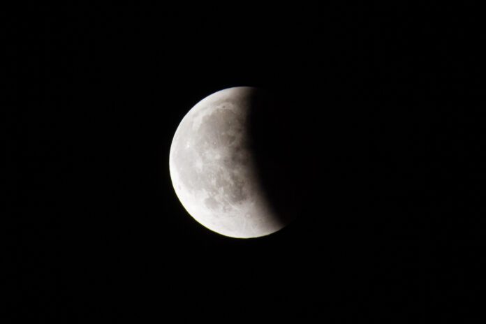 partial-lunar-eclipse-with-shadow-covering-a-portion-of-the-moon-against-black-night-sky