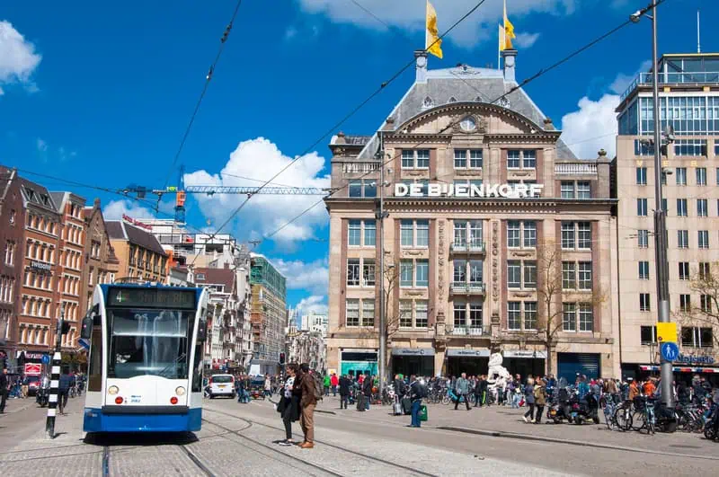 people-crossing-the-street-in-front-of-a-tram-in-amsterdam-dam-square