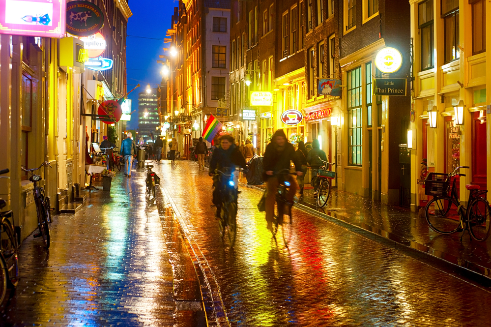 photo-of-people-cycling-in-amsterdam-street-in-rain