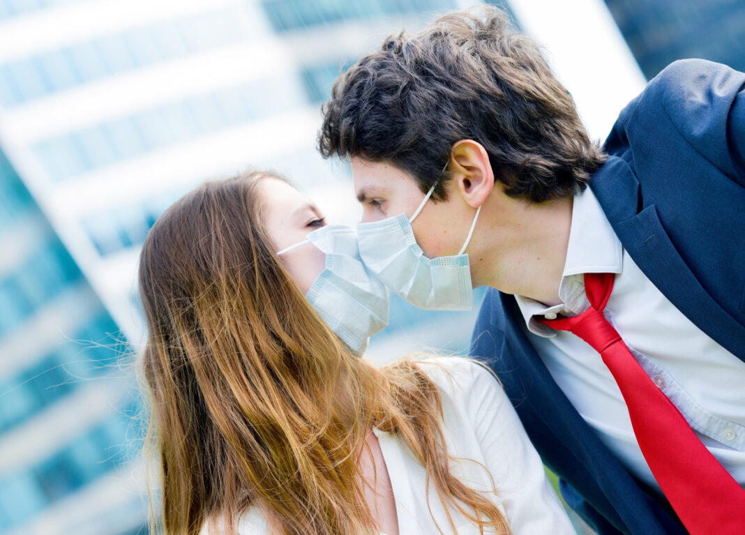woman-and-man-kissing-with-masks-on