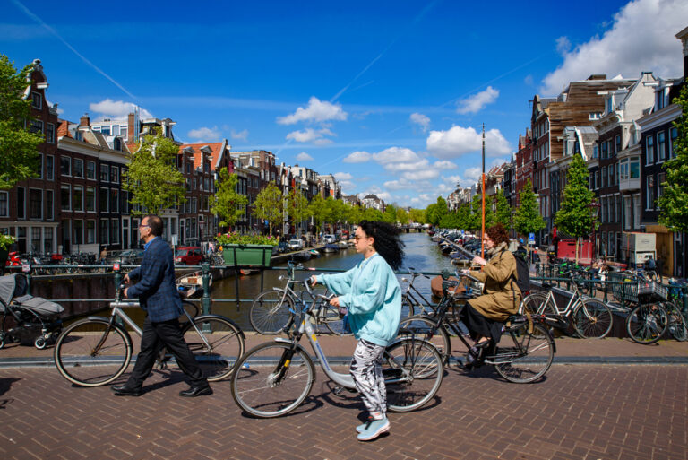 photo-of-people-riding-bikes-along-amsterdam-bridge