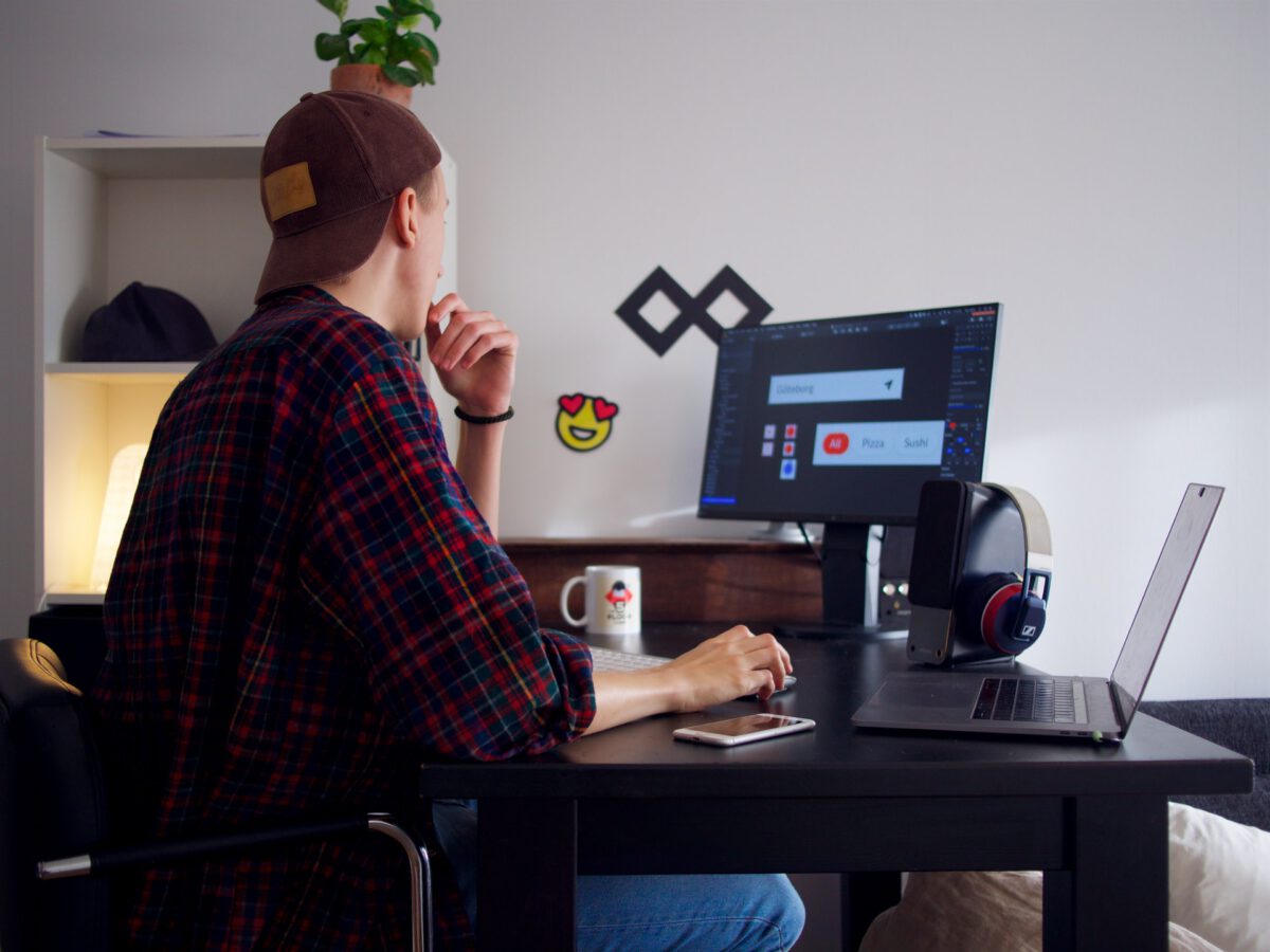 Photo-of-freelance-worker-sitting-at-desk-with-computers