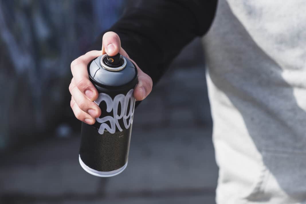 person-spray-painting-car-in-amsterdam-netherlands-with-the-word-cheater