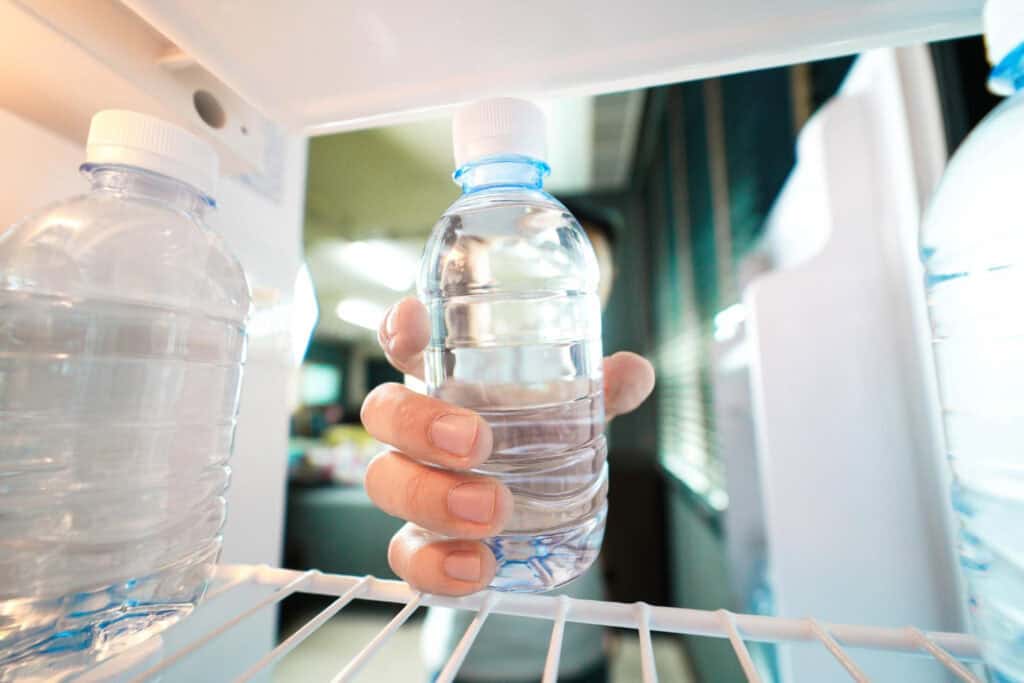 photo-of-person-taking-water-bottle-from-inside-of-fridge