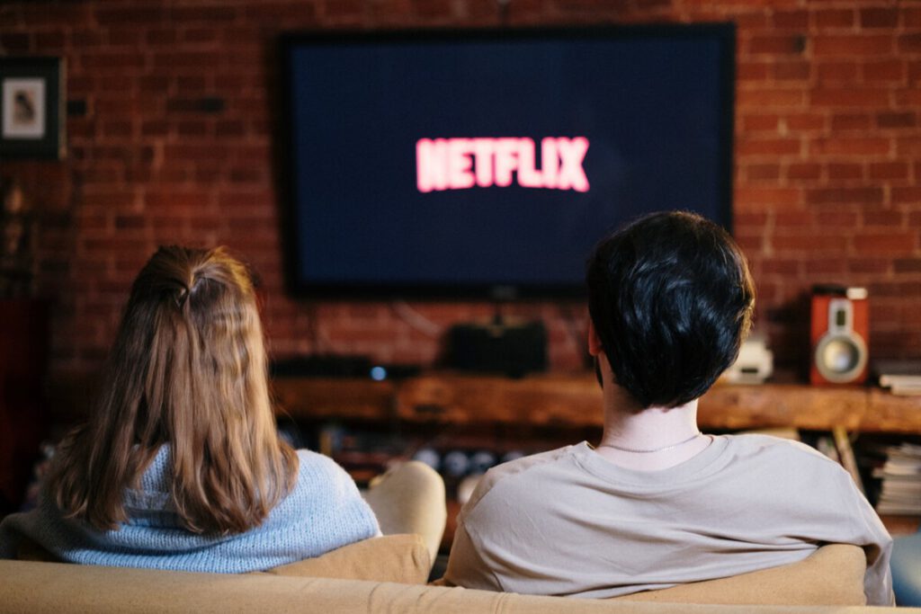 Photo-of-couple-sitting-on-couch-watching-tv