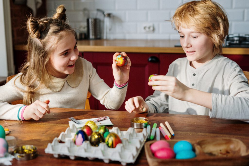 two-dutch-children-painting-easter-eggs-at-the-kitchen-table