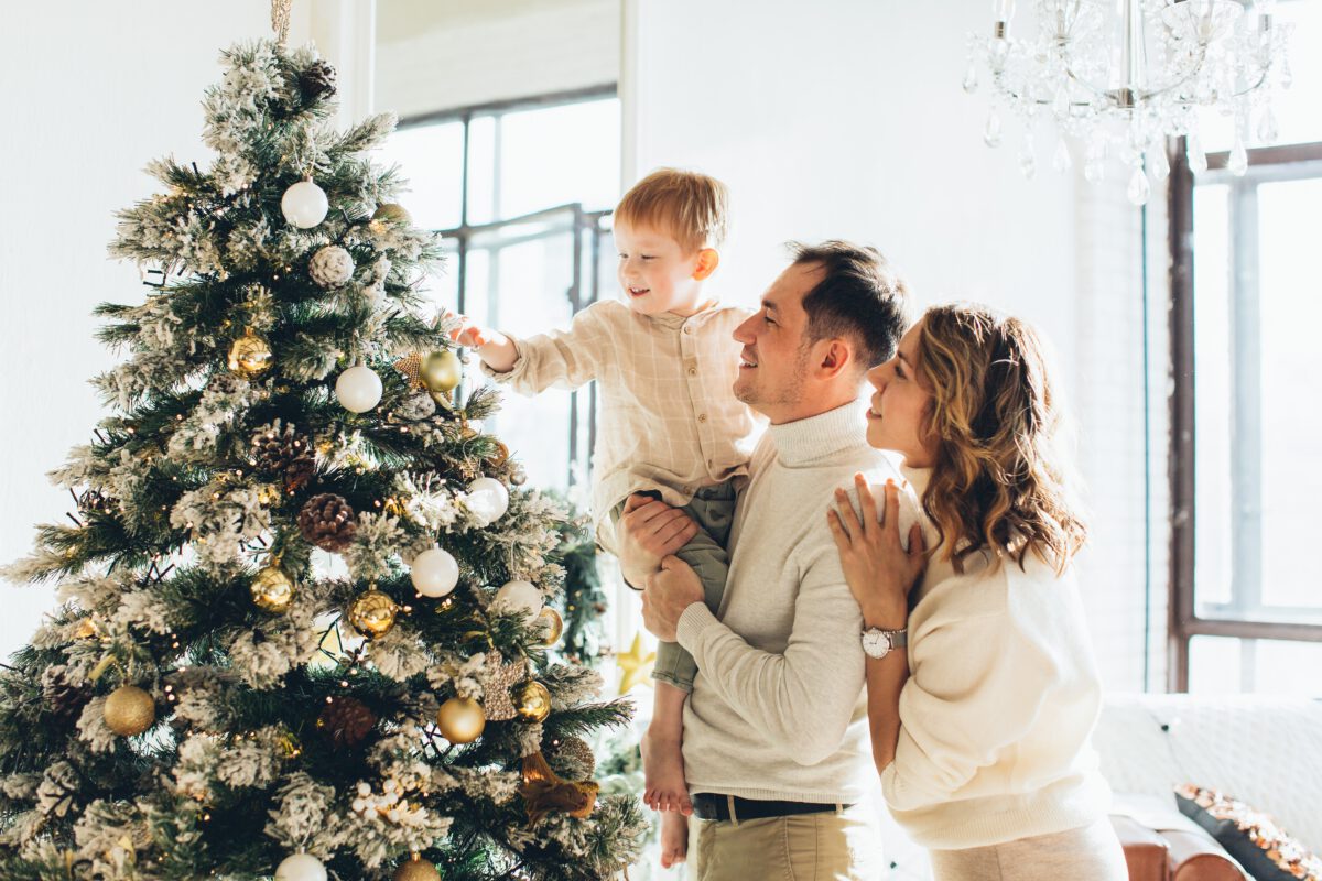 couple-with-their-son-looking-at-a-christmas-tree