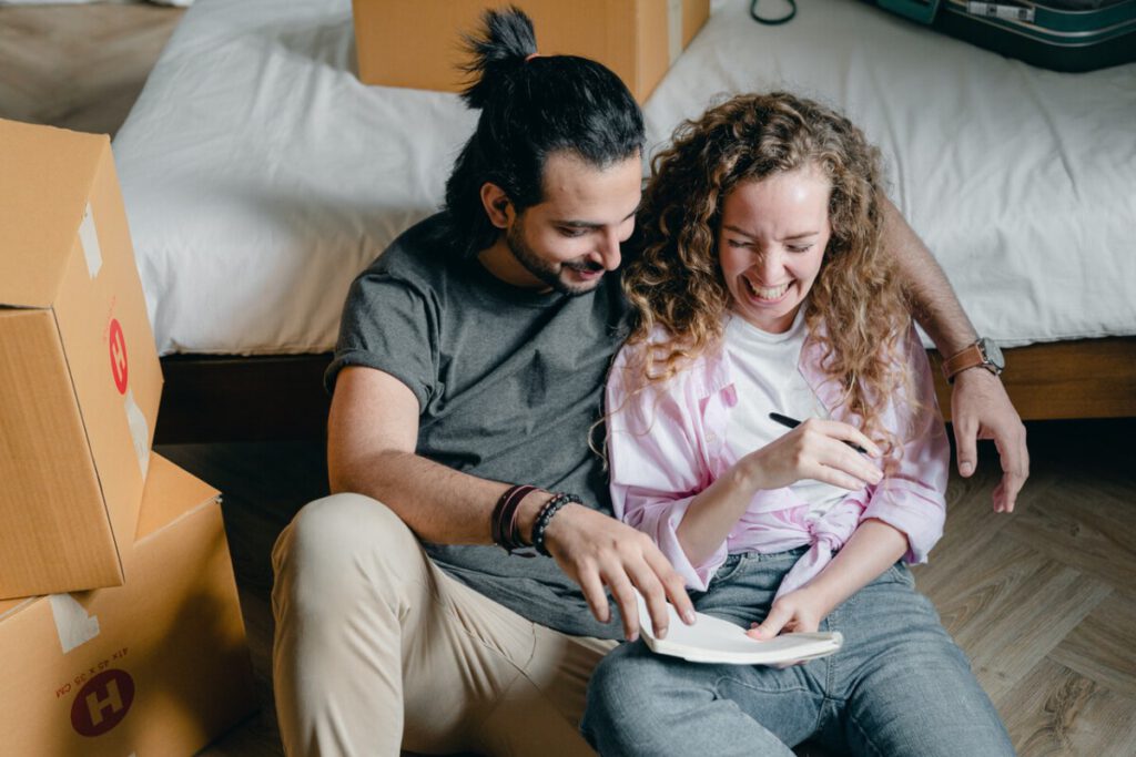 Young-couple-sitting-on-their-new-bedroom-floor-in-an-antikraak-house