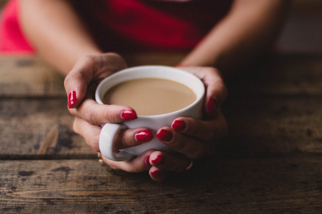woman-with-red-finger-nails-holding-cup-of-tea