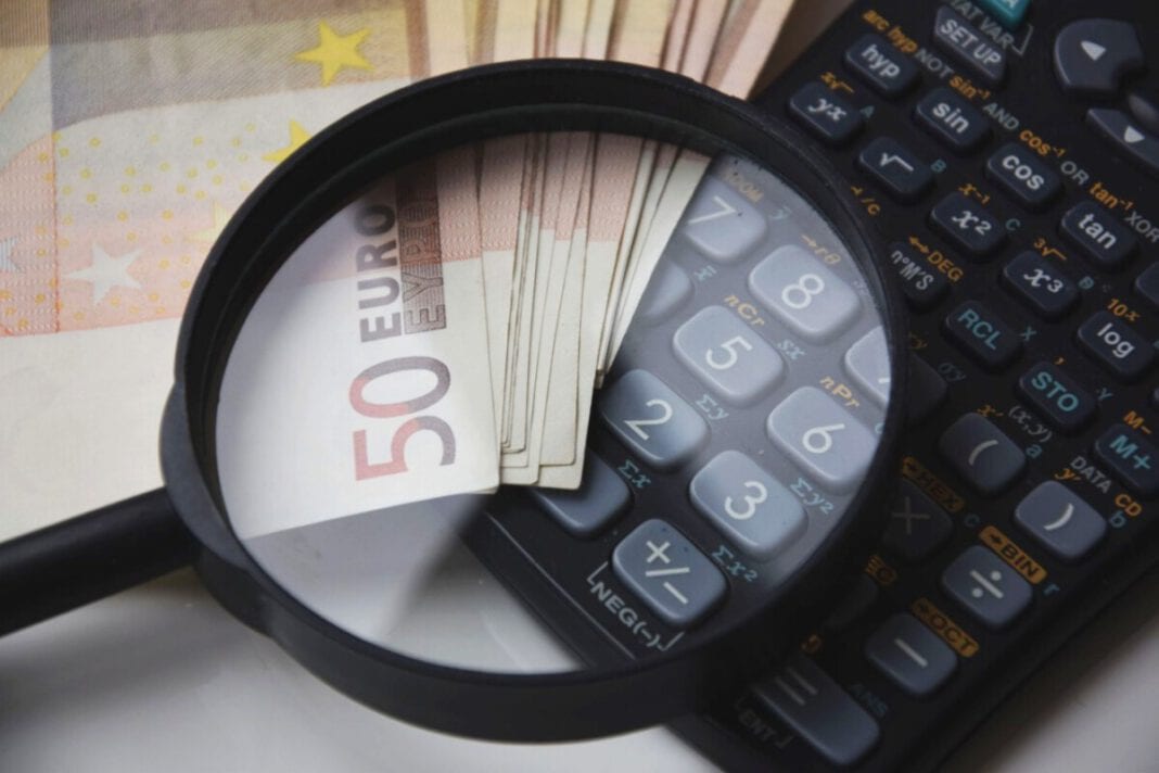 photo-of-magnifying-glass-on-calculator-and-money-tax