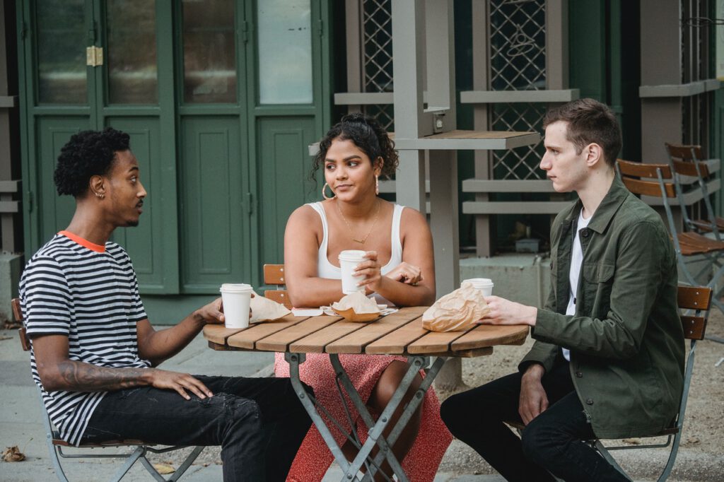 Photo-of-three-people-sitting-at-table-outside-drinking-coffee-in-netherlands