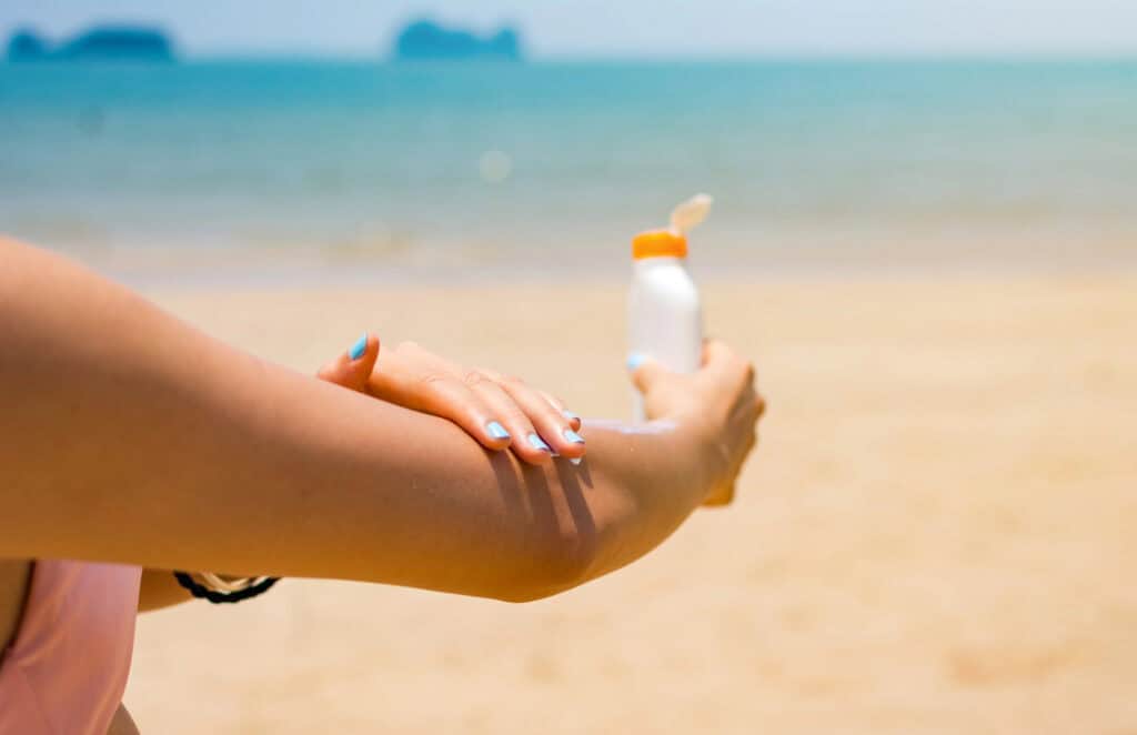 photo-of-a-person-putting-suncreen-at-the-beach