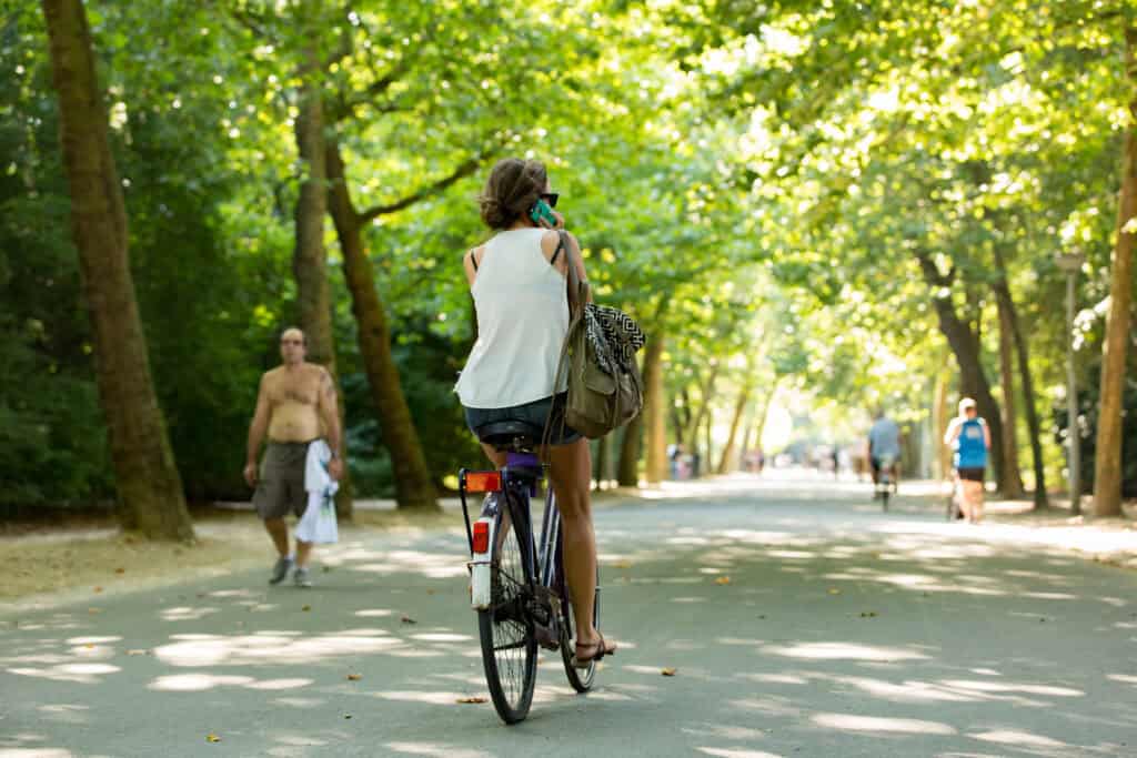 photo-of-a-woman-cycling-in-vondelpark-amsterdam-on-the-phone
