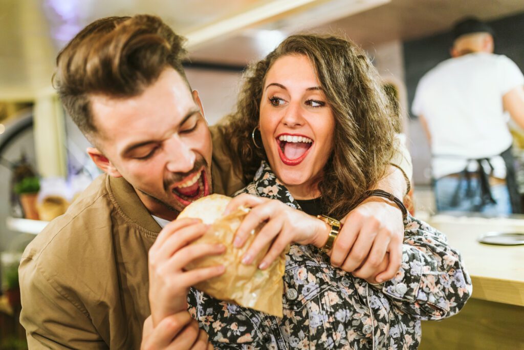 photograph-of-a-tall-dutch-man-lunging-to-take-a-bite-out-of-his-girlfriends-cheese-sandwich