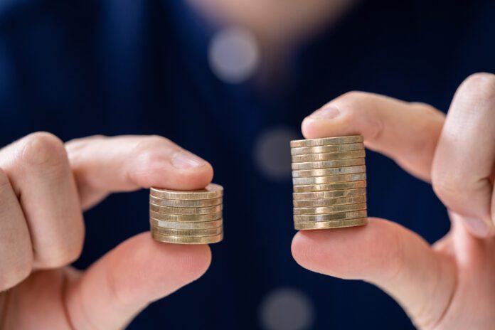 photograph-of-a-man-holding-two-stacks-of-coins-representing-dutch-gender-pay-gap