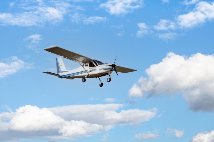 photograph-of-a-single-engine-ultralight-plane-flying-blue-sky-with-white-clouds