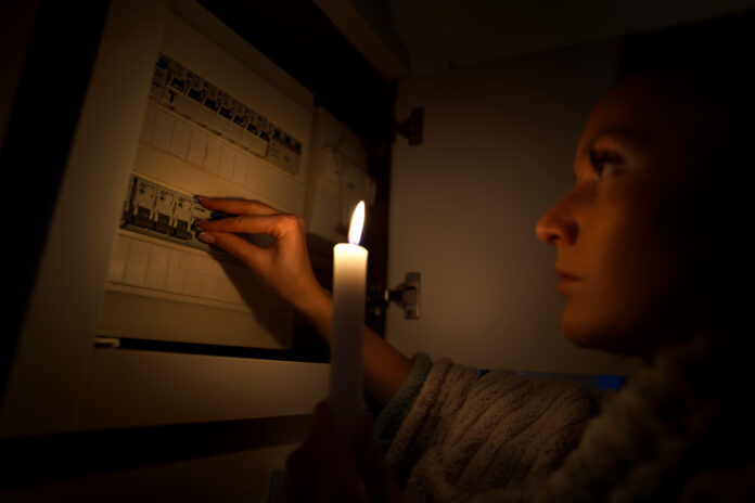 photograph-of-a-woman-investigating-a-fuse-box-in-the-dark