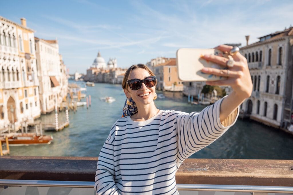 photograph-of-a-woman-taking-a-selfie-on-a-bridge-in-venice