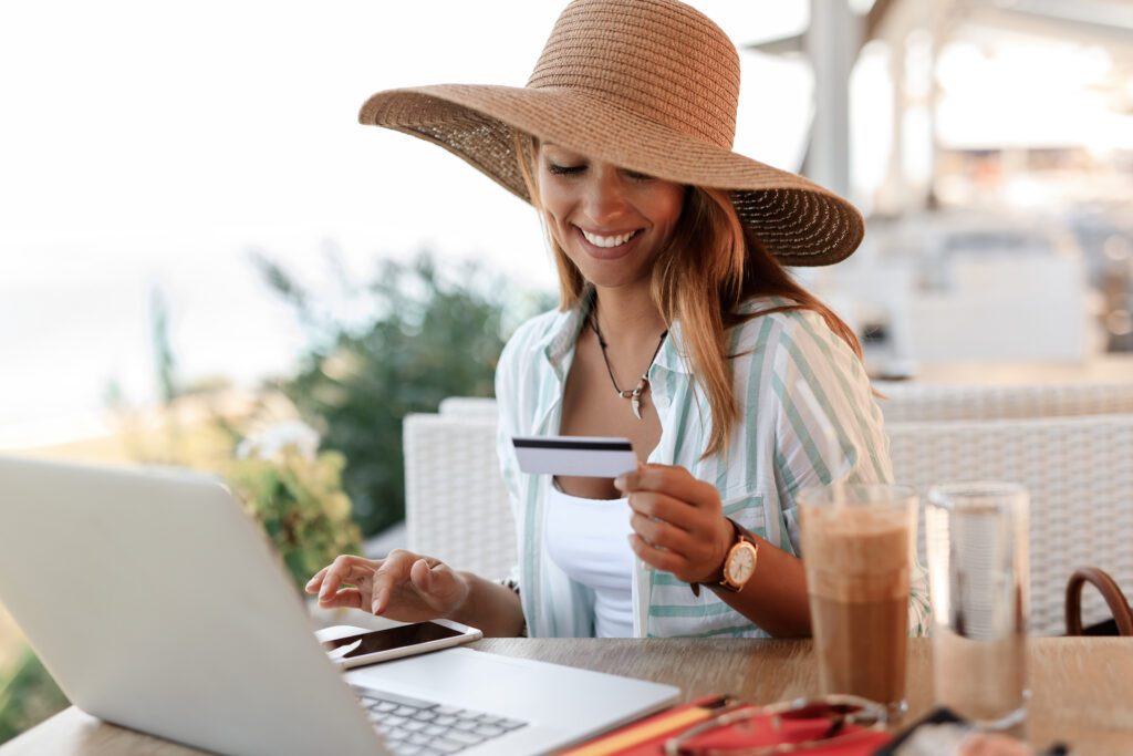photograph-of-a-zzp'er-typing-on-her-phone-and-looking-at-a-bank-card-while-on-holiday