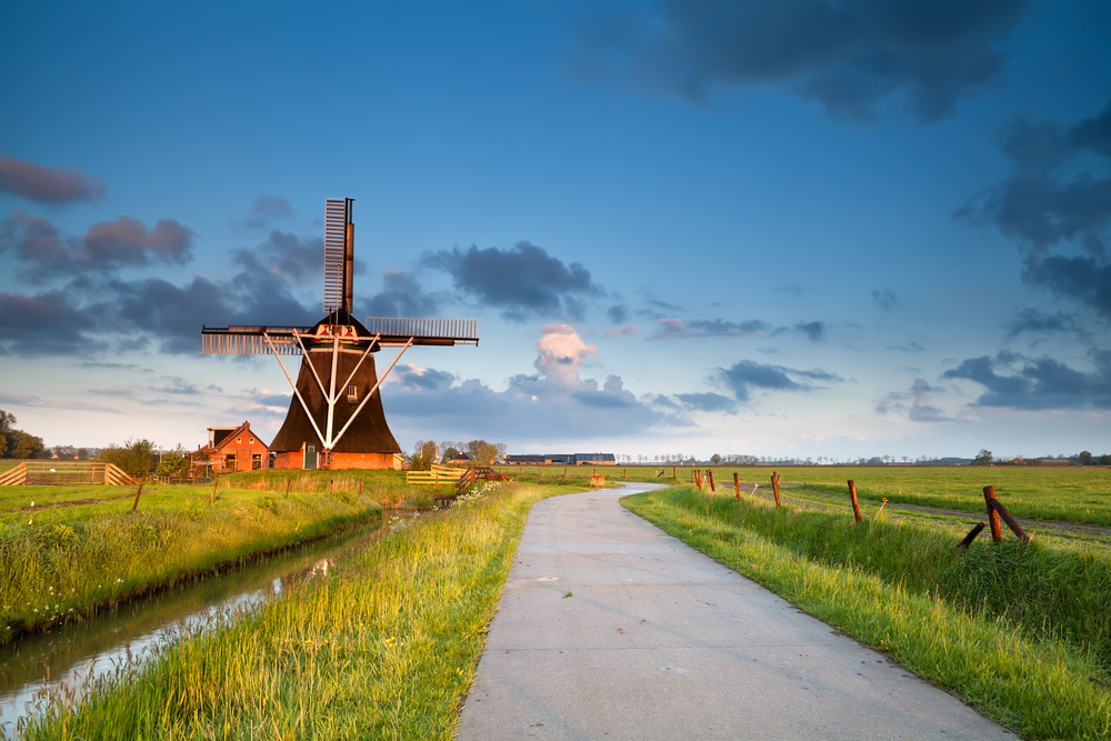 photograph-of-the-countryside-in-groningen-with-a-windmill-in-the-background