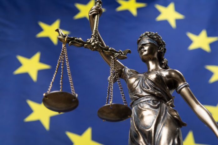photograph-of-the-european-union-flag-with-the-goddess-of-justice-holding-a-weighing-scale-in-the-foreground