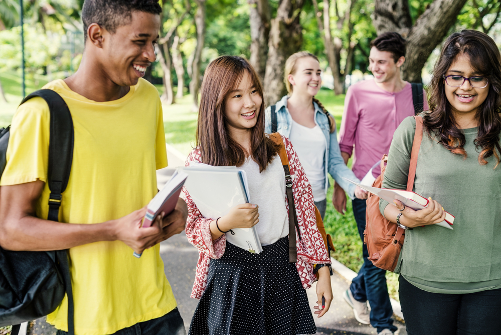 picture-of-diverse-students-walking-and-laughing-with-books-in-hand-studying-Breukelen