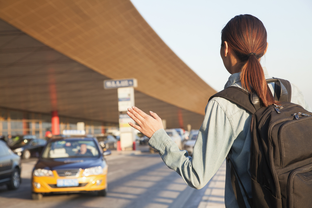 picture-of-woman-hailing-a-taxi-cab-at-airport