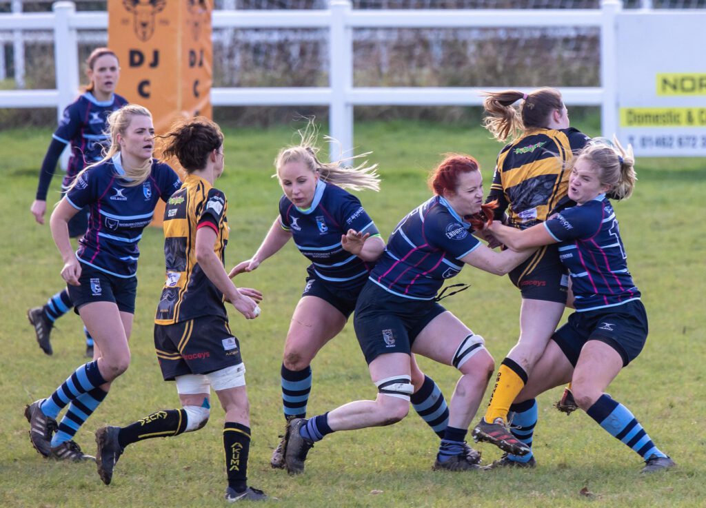picture-of-women-tackling-each-other-playing-rugby-on-field