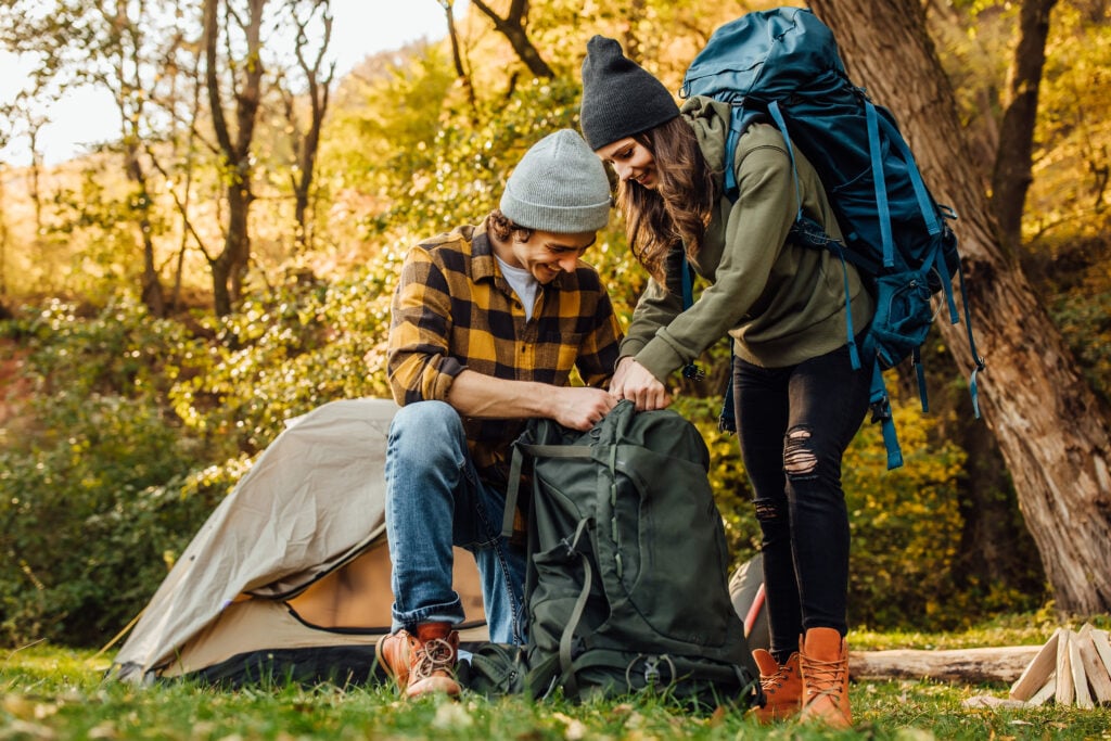 picture-of-young-couple-gathering-backpack-for-hike-while-camping-in-france