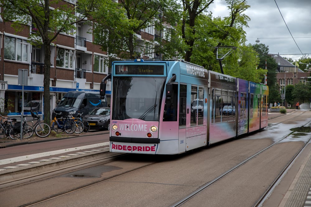 front-view-of-rainbow-coloured-tram-riding-through-amsterdam