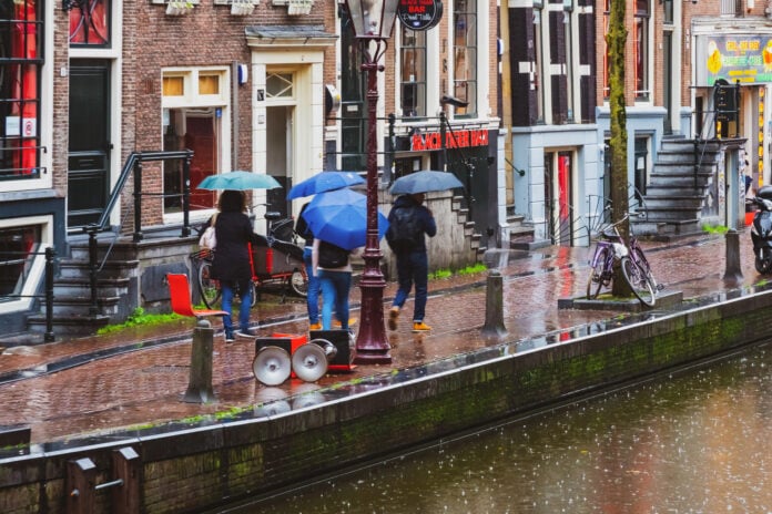 photo-of-people-walking-with-umbrellas-on-rainy-amsterdam-day-by-canal