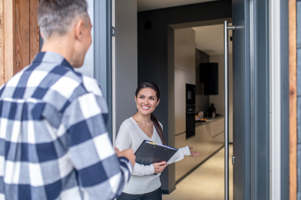 photo-of-real-estate-agent-opening-door-and-welcoming-man-to-house-viewing