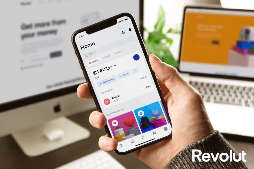 photo-of-hand-holding-revolut-app-showing-banking-in-euros-in-netherlands-in-front-of-laptop
