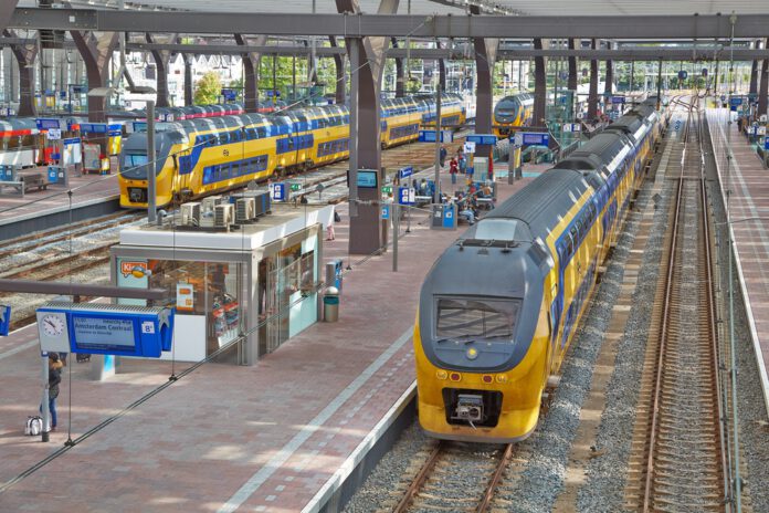 high-up-view-of-blue-and-yellow-train-entering-platform-indoors-at-rotterdam-central-station