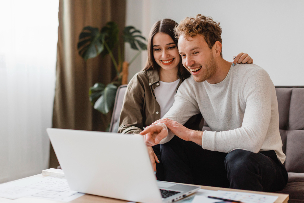 photo-of-man-and-woman-pointing-and-smiling-at-laptop-after-Dutch-realtor-put-their-home-up-on-Funda