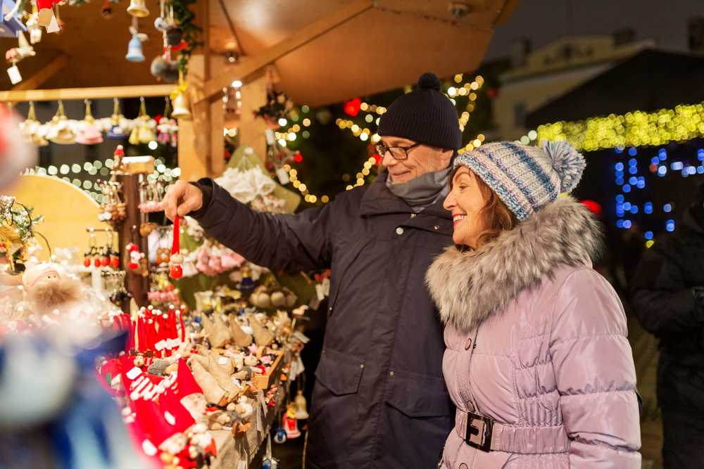 senior-couple-at-a-christmas-market-in-france-buying-decorations