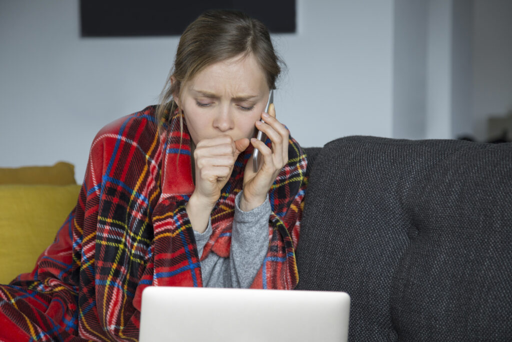 photo-of-sick-young-woman-in-the-netherlands-coughing-calling-her-doctor-on-the-phone